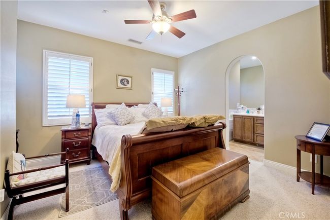 Primary suite provides lovely arched doorways, ceiling fan and offers large walk-in closet | Image 26