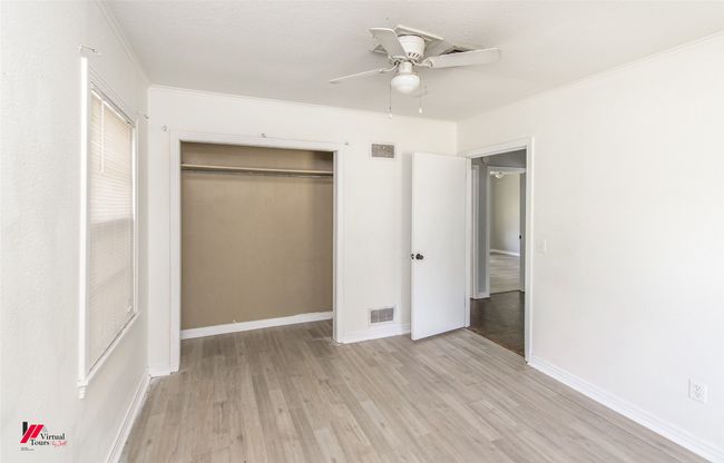 Unfurnished bedroom featuring a closet, ornamental molding, visible vents, and light wood-style floors | Image 4