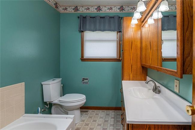 Bathroom with a bath, tile patterned floors, and vanity | Image 15