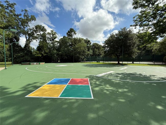 Outdoor sports court surrounded by trees, featuring multiple game markings and a hopscotch area. Perfect for recreational activities in a natural setting. | Image 37