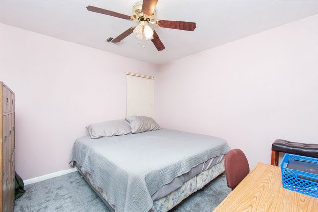 Carpeted bedroom featuring visible vents, baseboards, and ceiling fan | Image 15