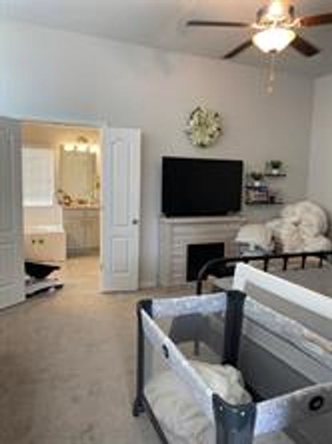 Bedroom with a fireplace, ceiling fan, ensuite bathroom, and carpet flooring | Image 8