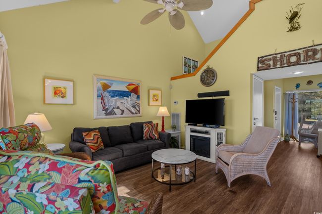 Living room featuring high vaulted ceiling, wood finished floors, and ceiling fan | Image 10