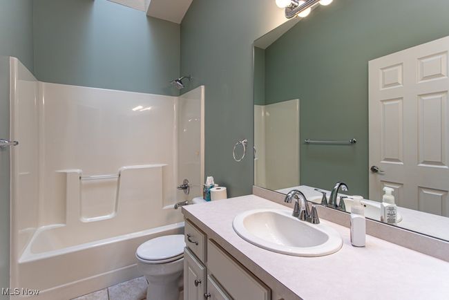 Bathroom featuring vanity, bathtub / shower combination, and tile patterned flooring | Image 30