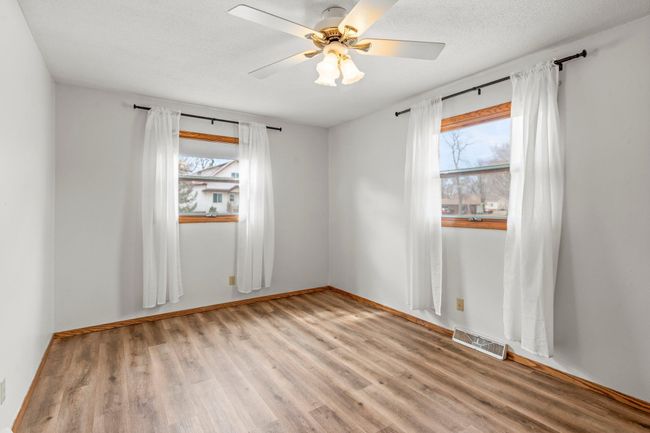 One bedroom includes a ceiling fan, and both are conveniently situated just steps away from a shared full bathroom. | Image 7
