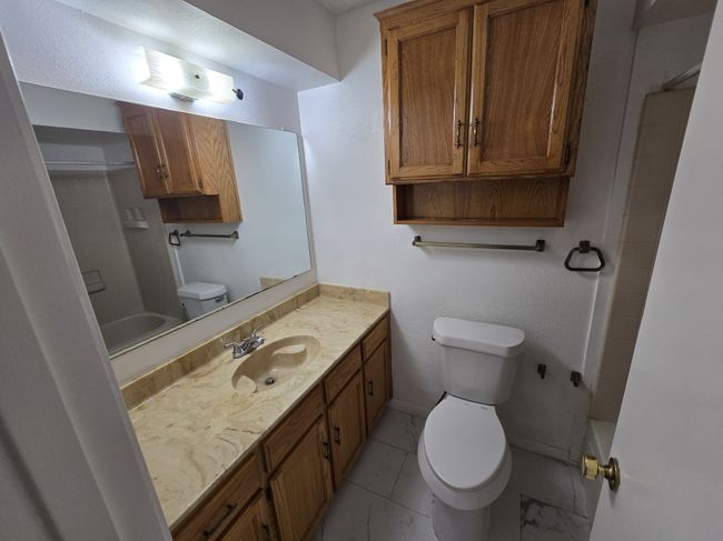 Bathroom with marble finish floors, vanity, and shower / washtub combination | Image 11