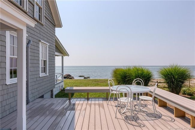 Side deck with dining and gas grill and enclosed outdoor shower with dressing room. | Image 12
