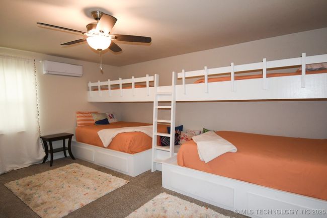Carpeted bedroom with a wall mounted AC and ceiling fan | Image 22