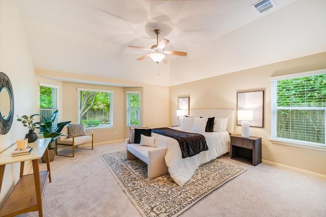 Bedroom featuring light colored carpet, vaulted ceiling, and a ceiling fan | Image 23