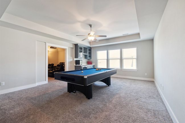 Playroom with pool table, carpet floors, a ceiling fan, and a tray ceiling | Image 27