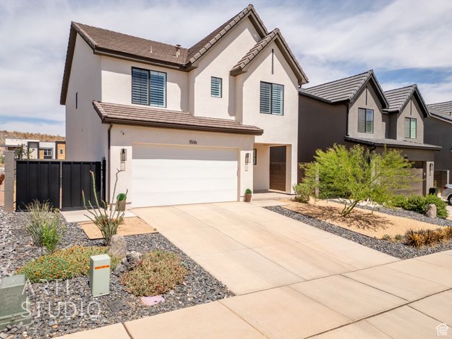 View of front of house with stucco siding, fence, driveway, and a garage | Image 40