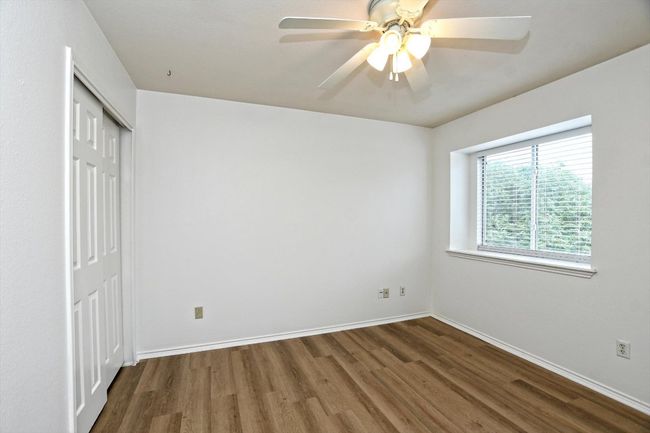 Unfurnished bedroom with wood finished floors, a closet, and a ceiling fan | Image 22