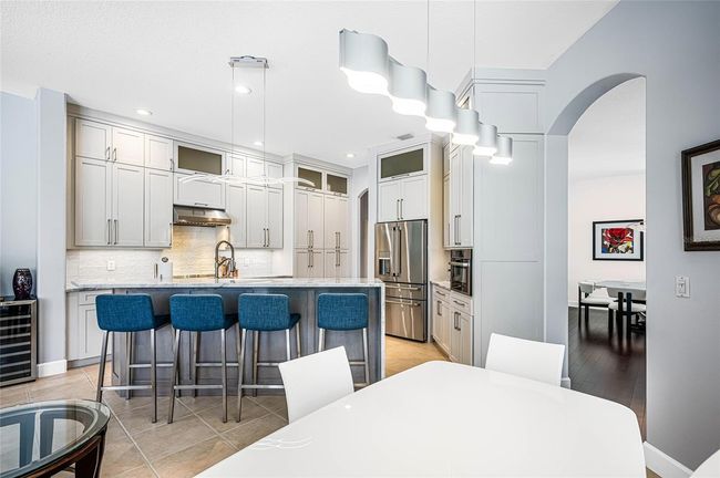 Stunning kitchen with bar seating, ample cabinetry, beautiful lighting fixtures and everything you need and more for cooking and entertaining! | Image 11