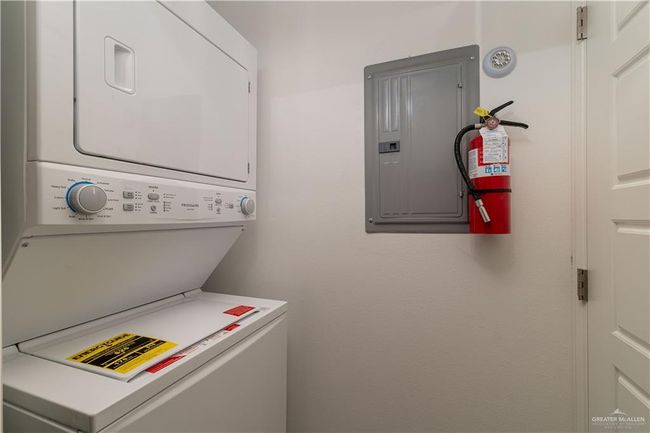 Laundry room featuring stacked washer and dryer, laundry area, and electric panel | Image 13