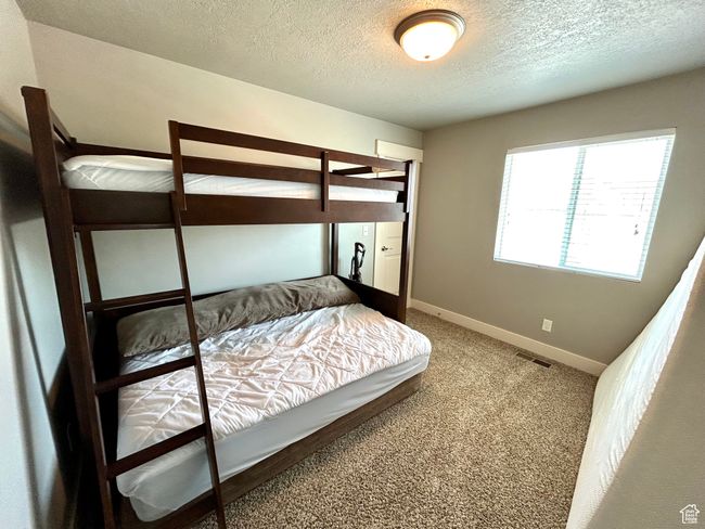 Bedroom featuring a textured ceiling, baseboards, and carpet floors | Image 19