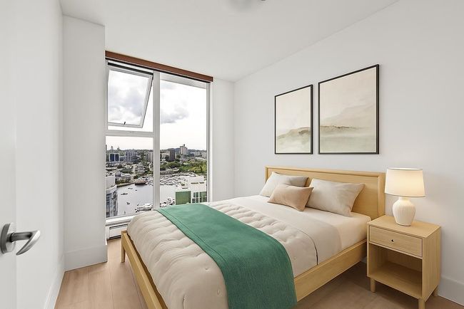 Bedroom with a wall of windows, light wood-type flooring, a water view, and a baseboard heating unit | Image 21