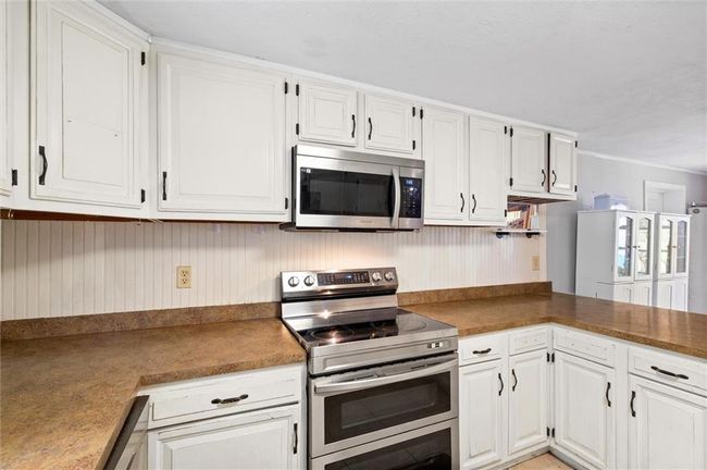 Kitchen featuring white cabinets and stainless steel appliances. | Image 6
