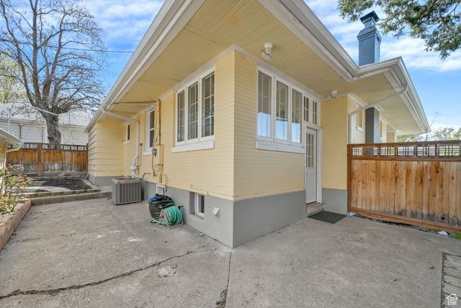 View of property exterior with fence, a chimney, cooling unit, and a patio | Image 25
