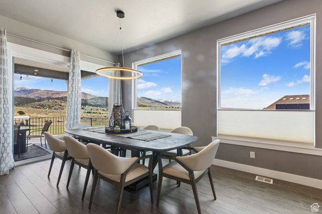 Dining space with wood finished floors, visible vents, baseboards, and a mountain view | Image 9