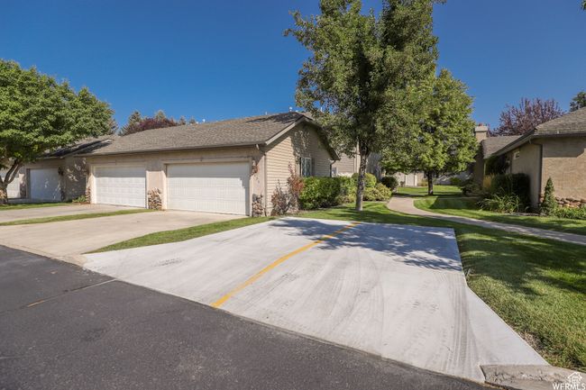 View of front of property featuring a front yard, concrete driveway, and a garage | Image 42