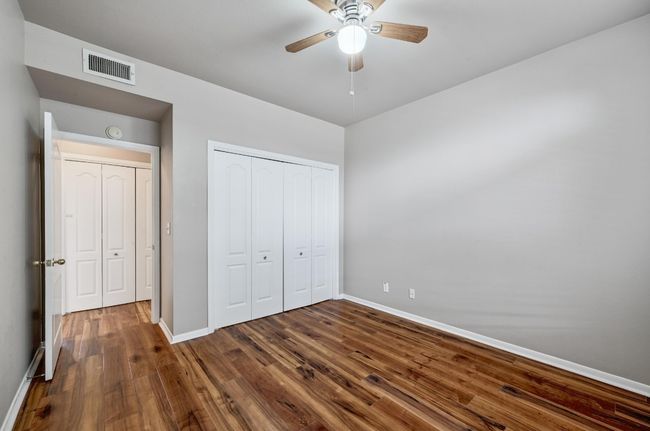 Unfurnished bedroom featuring dark wood-style floors, a closet, and ceiling fan | Image 21
