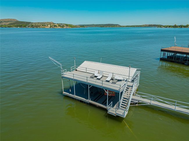 Dock area featuring boat lift and a water view | Image 11