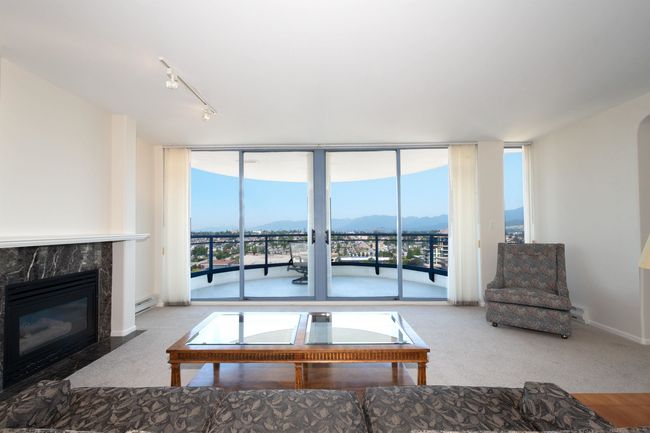 Living area featuring rail lighting, a baseboard heating unit, a wall of windows, and plenty of natural light | Image 5