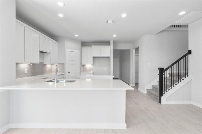Another view of this spacious kitchen! Pictured here is the staircase leading to second floor. | Image 6