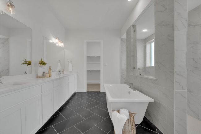 Full bathroom with a freestanding bath, double vanity, a spacious closet, and a sink | Image 27