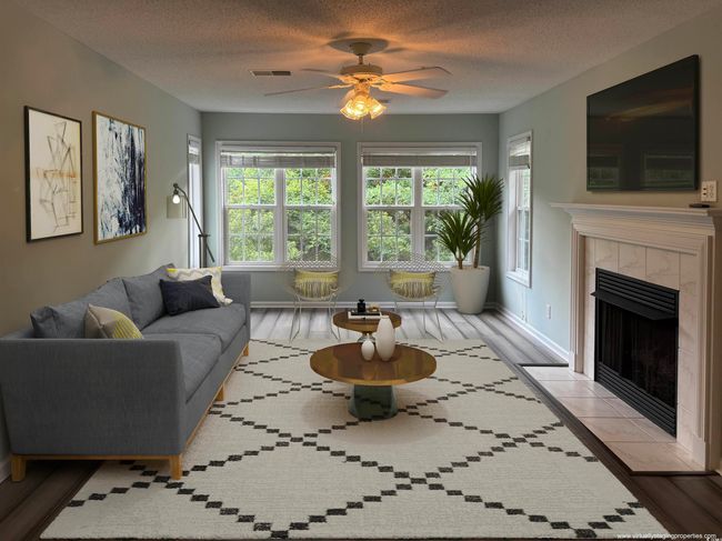 Living room with ceiling fan, a tile fireplace, wood finished floors, baseboards, and a textured ceiling | Image 12