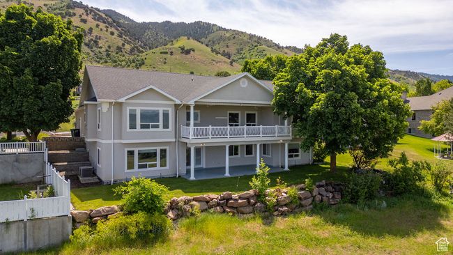 Back of property featuring a patio area, a mountain view, stucco siding, and central AC unit | Image 36
