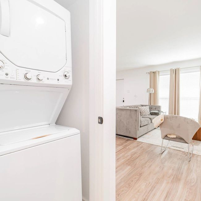 Clothes washing area featuring wood finished floors and stacked washer and clothes dryer | Image 14