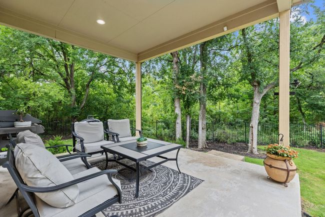 Fenced backyard with outdoor lounge area, a patio, view of wooded area, and grilling area | Image 34