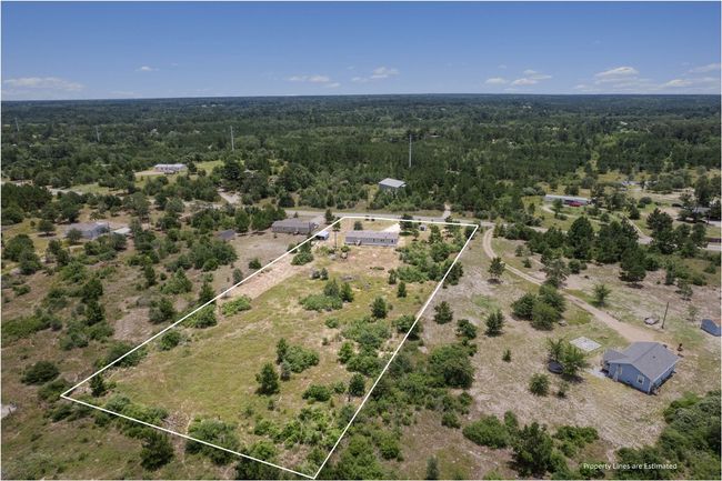 Aerial view of property's location with a heavily wooded area and property parcel outlined | Image 35