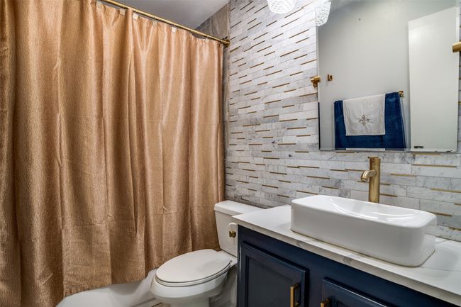 Bathroom featuring toilet, vanity, and a shower with curtain | Image 15
