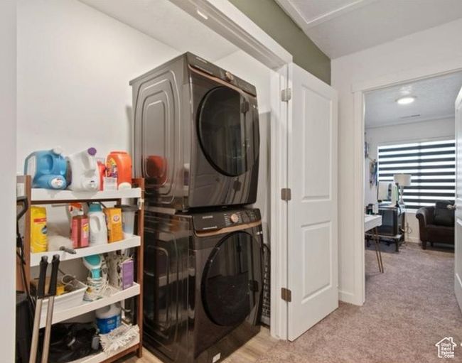 Washroom with estacked washer and dryer and carpet floors | Image 22