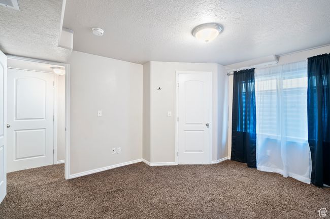 Unfurnished bedroom with a textured ceiling and carpet floors | Image 23