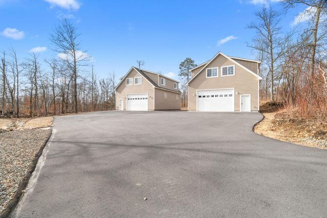 Garage on right belongs to the 8087 unit. Garage is heated, insulated, 10ft door, utility area with running water, floor drain, tankless water heater, and mini split. Above the garage is a newly finished 1, 040 sqft guest suite. | Image 5