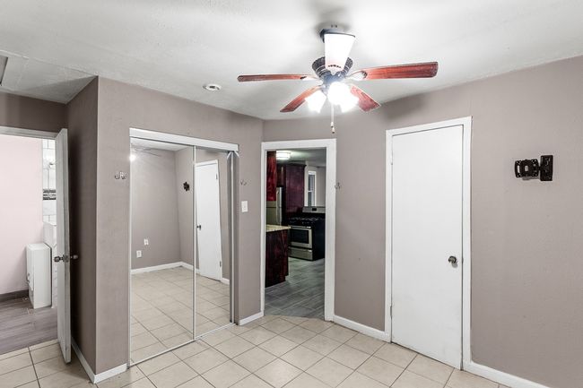 Unfurnished bedroom featuring baseboards, light tile patterned floors, and ceiling fan | Image 35