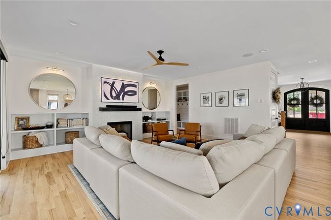 Living room featuring french doors, light wood-style flooring, a large fireplace, a ceiling fan, and recessed lighting | Image 21