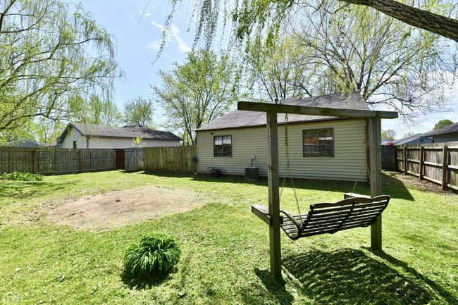 back of house featuring a yard, central air condition unit, and a fenced backyard | Image 12