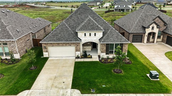 French provincial home featuring brick siding, driveway, a garage, and stone siding | Image 31