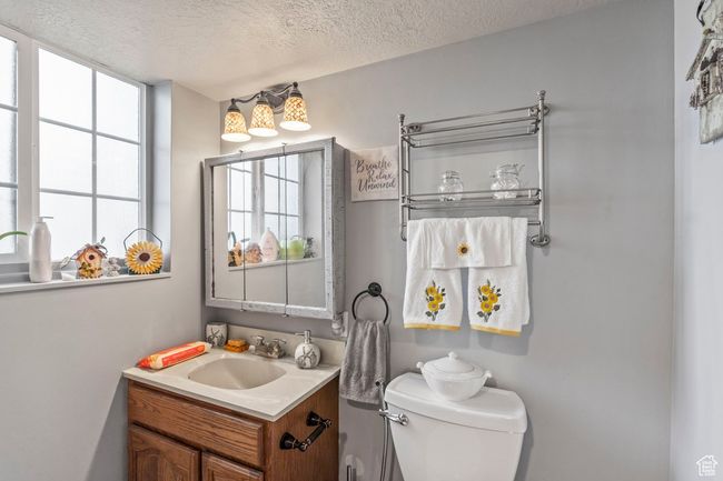 Bathroom with a textured ceiling, vanity, and toilet | Image 23