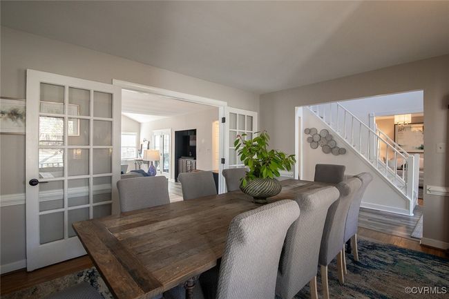 Dining area with a chandelier, stairs, baseboards, and wood finished floors | Image 7