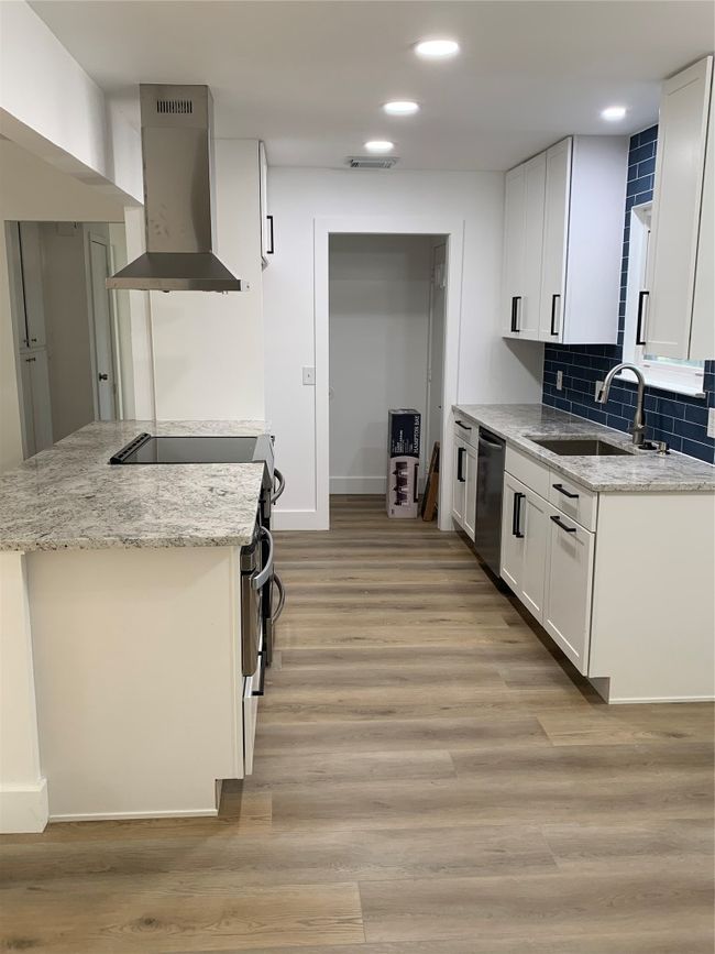 Kitchen featuring exhaust hood, recessed lighting, stove, white cabinetry, and light wood finished floors | Image 18