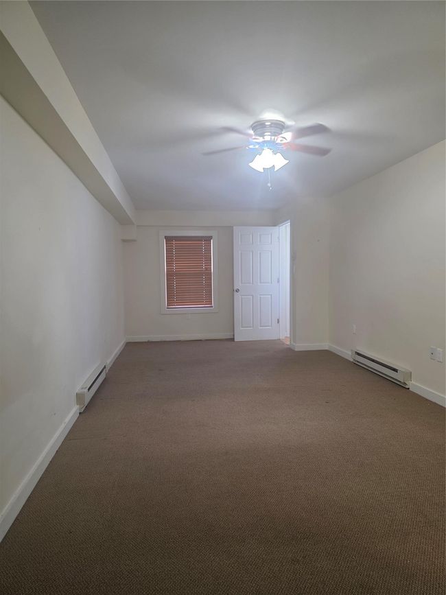 Carpeted empty room with baseboard heating and baseboards | Image 10