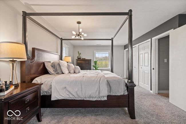 bedroom with carpet and a chandelier | Image 24