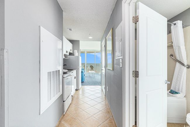 Hall featuring a textured ceiling and light tile patterned floors | Image 10