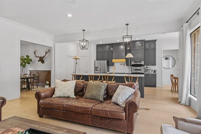 Living area with light wood-type flooring, baseboards, an inviting chandelier, recessed lighting, and ornamental molding | Image 8