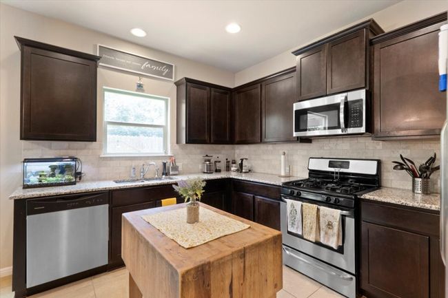 Open concept kitchen with window at the sink, perfect for gazing out to the greenbelt and observing wild life as you tackle the dishes. | Image 5